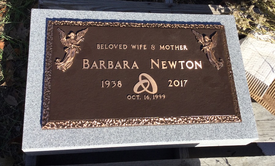 A bronze memorial plaque mounted on a granite base