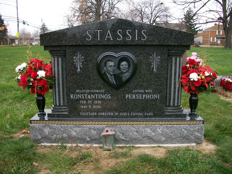A dark granite companion memorial with columns and an etched portrait of a husband and wife